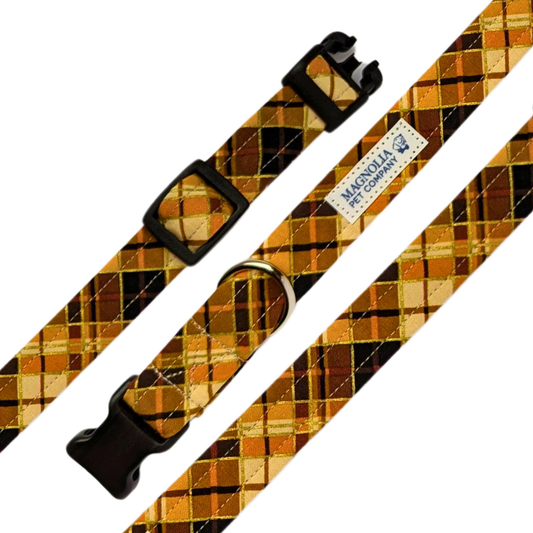 his collar features a timeless plaid pattern in warm tones of brown, black, and orange, complemented by subtle gold accents that catch the light beautifully.