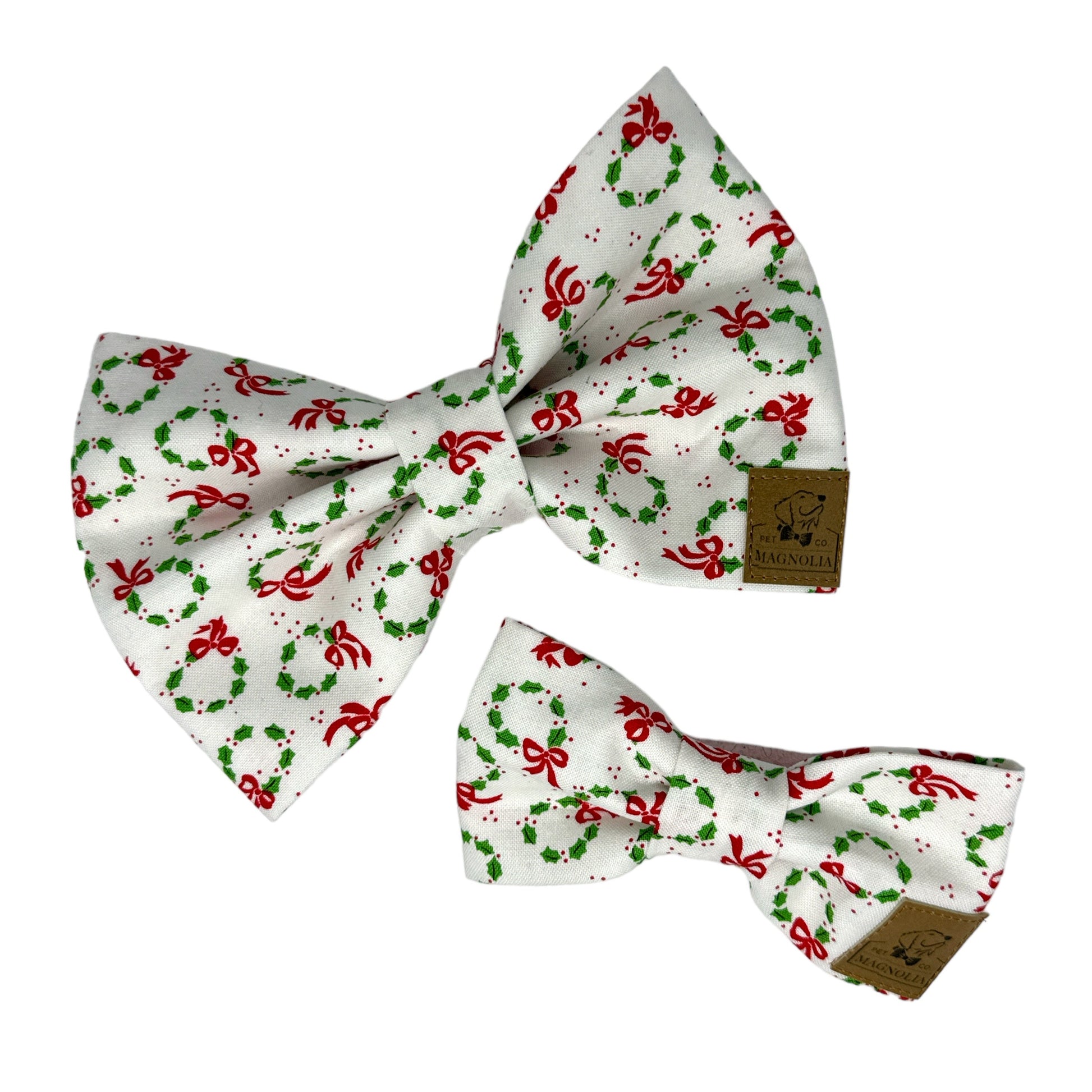 Dog bow tie featuring vibrant green Christmas wreaths and cheerful red bows on a white background.