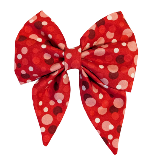 Crafted from bright red fabric with large polka dots in varying shades of red