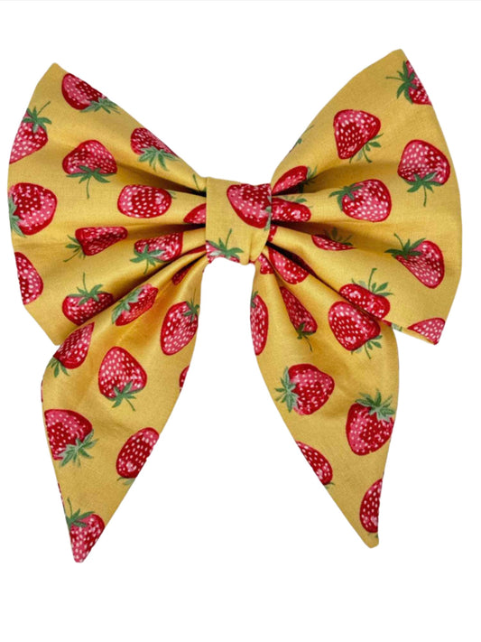 Crafted from warm yellow fabric, this charming bow features an array of pink strawberries in multiple shades, creating a delightful and vibrant accessory perfect for any dog.