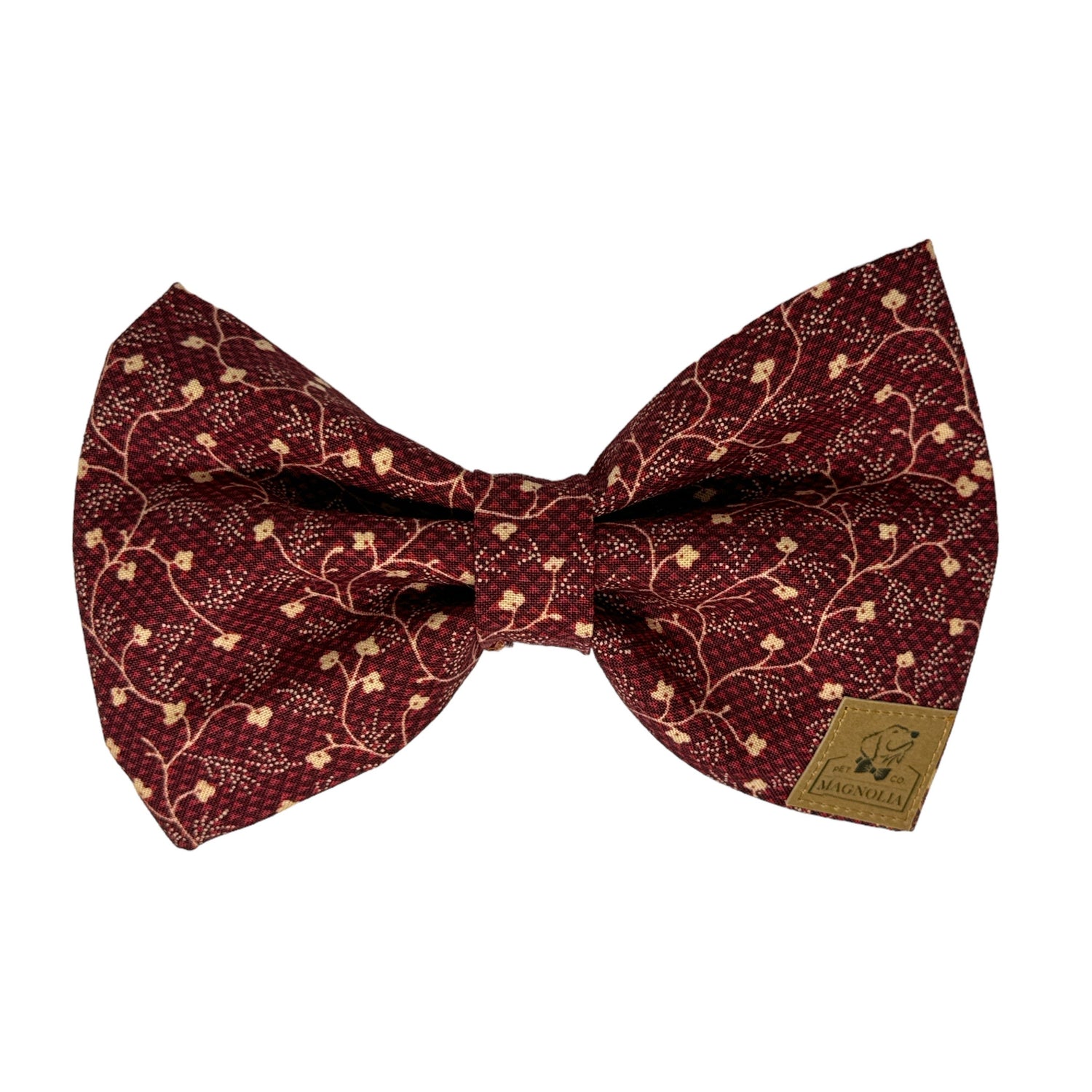 This sophisticated dog bow tie features a rich maroon fabric adorned with delicate off-white floral vine patterns that weave gracefully throughout the fabric